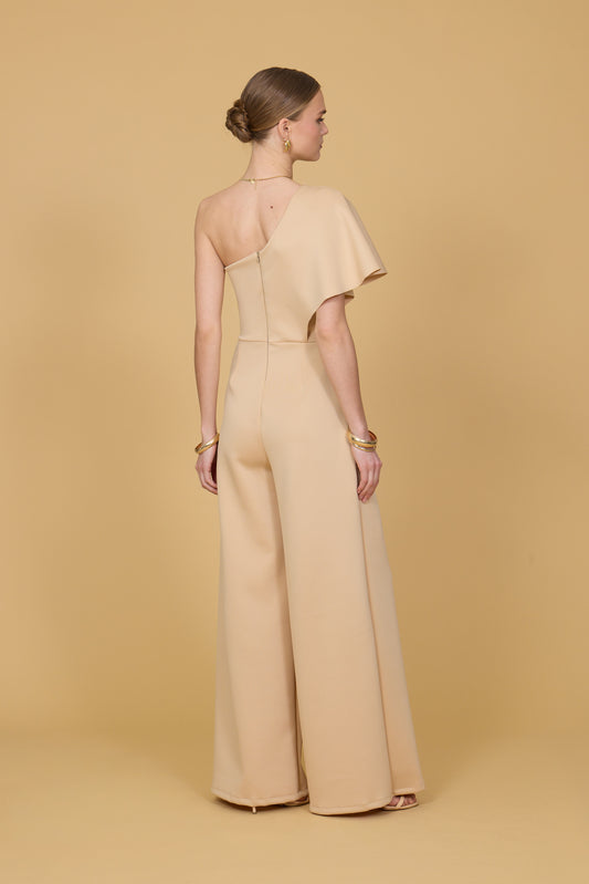 Woman wearing a beige jumpsuit against a beige background