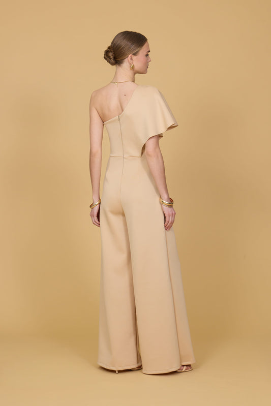 Woman wearing a beige jumpsuit against a beige background