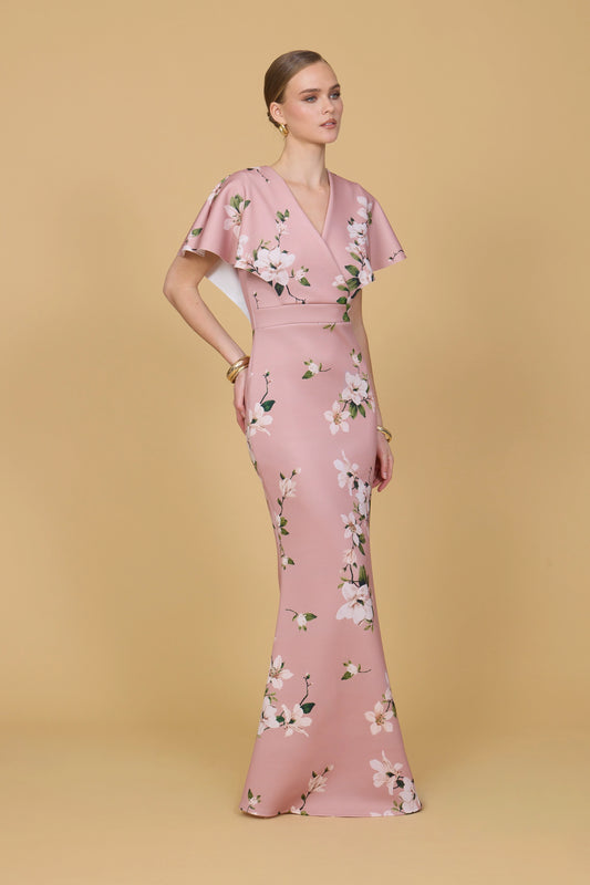 Woman wearing a pink floral dress against a beige background