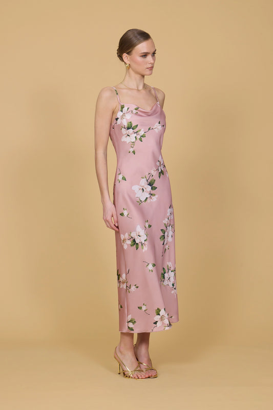 Woman wearing a pink floral dress against a beige background