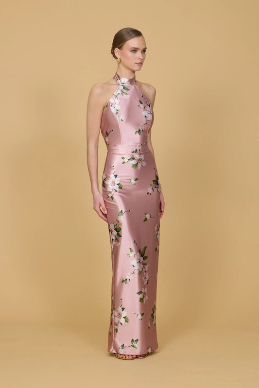 Woman wearing a pink floral dress against a beige background