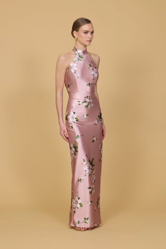 Woman wearing a pink floral dress against a beige background