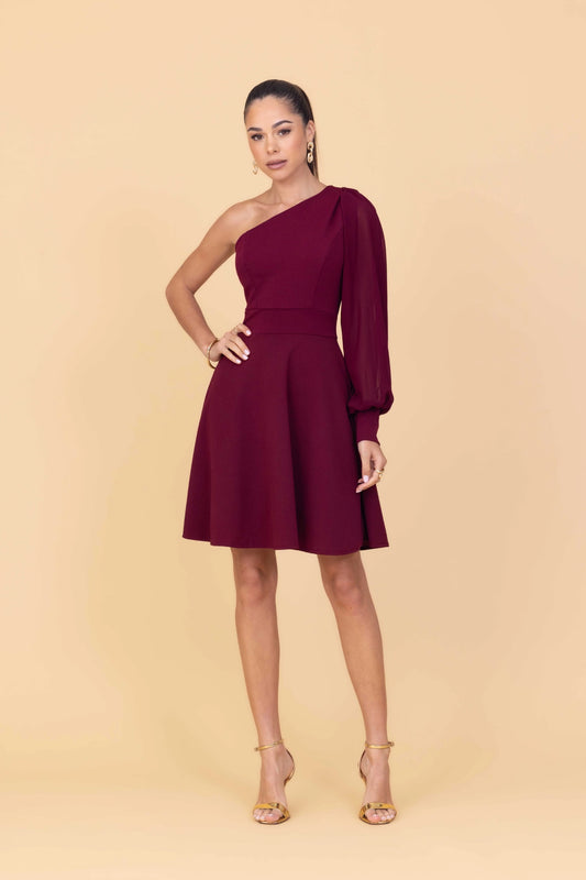 Woman wearing a burgundy one-shoulder dress on a beige background