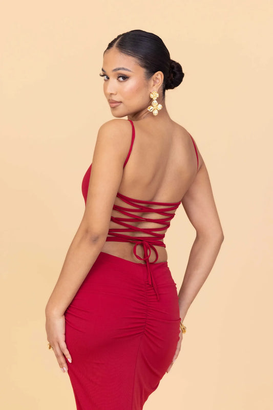 Woman wearing a red dress with a beige background