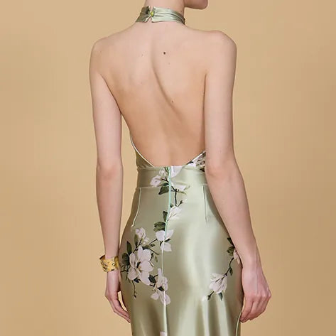 Woman wearing a green dress with floral patterns on a beige background