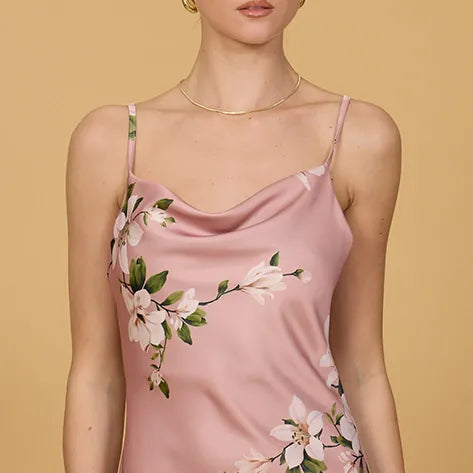 Woman wearing a pink floral camisole against a beige background