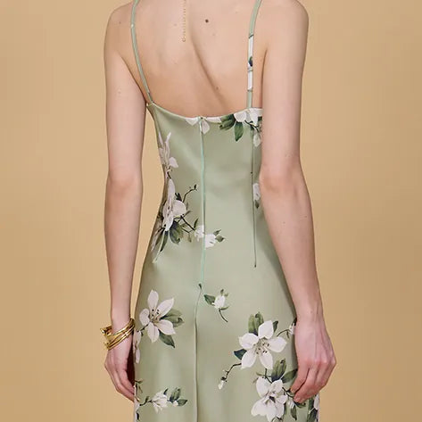 Green floral dress worn by a person on a beige background