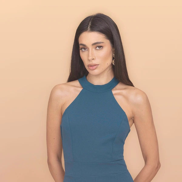 Woman wearing a blue dress against a beige background