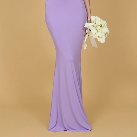 Woman wearing a purple dress against a beige background