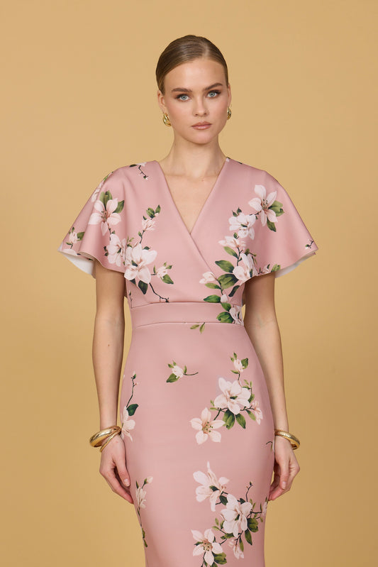 Woman wearing a pink floral dress against a beige background
