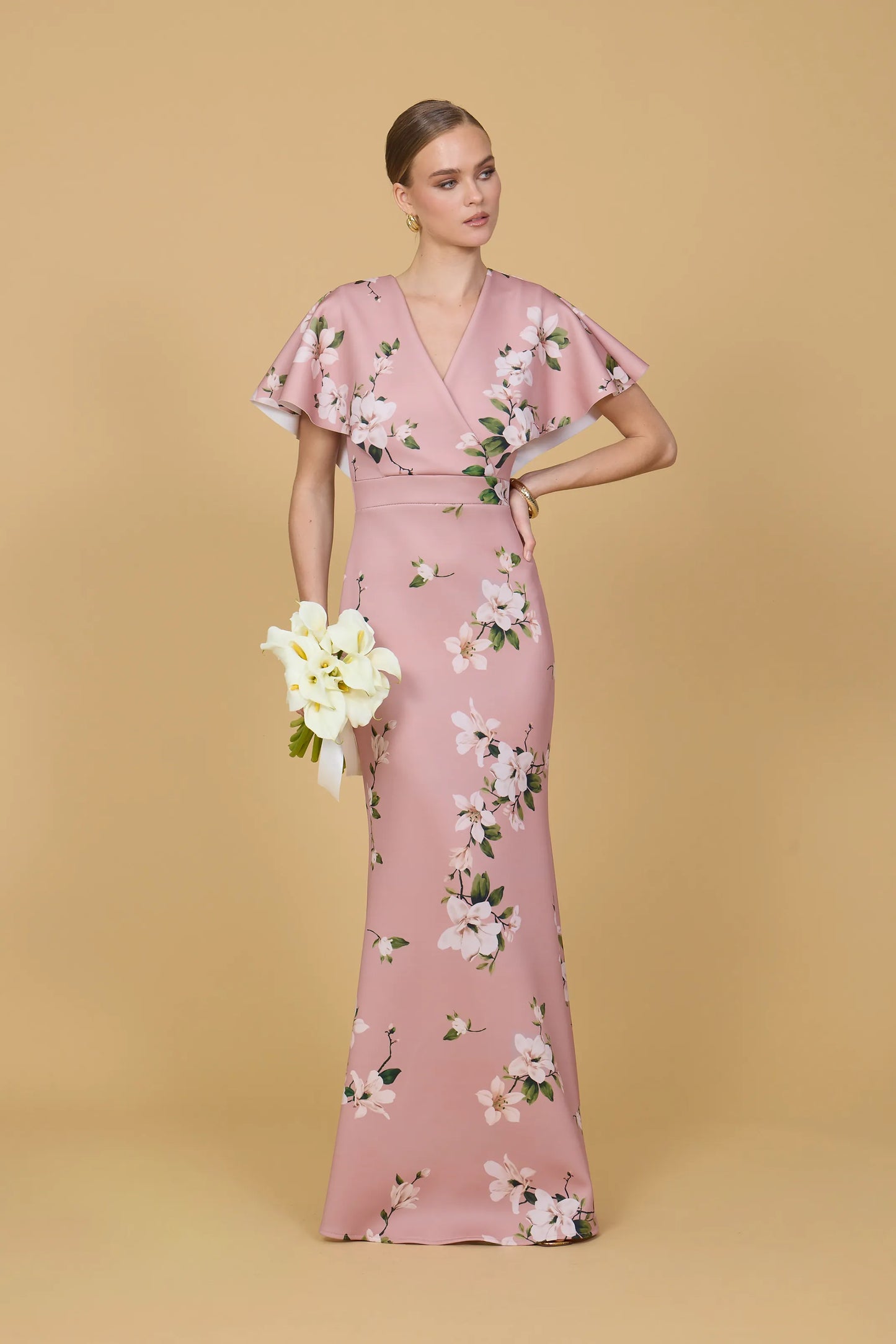 Woman wearing a pink floral dress against a beige background