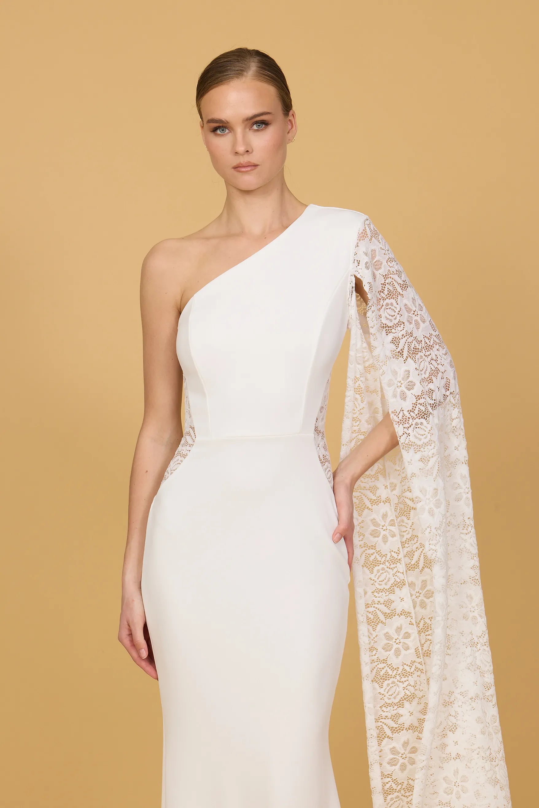 Woman wearing a white one-shoulder dress against a beige background