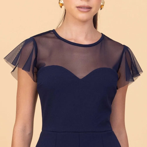 Navy blue dress with sheer sleeves on a beige background