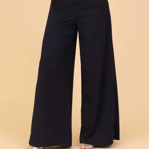Black wide-leg pants on a beige background