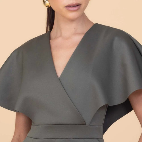 Gray cape worn by a person on a beige background