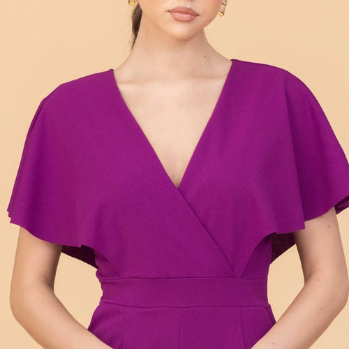 Purple dress with cape detail on a beige background