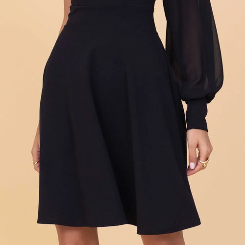 Black dress with long sleeves on a beige background