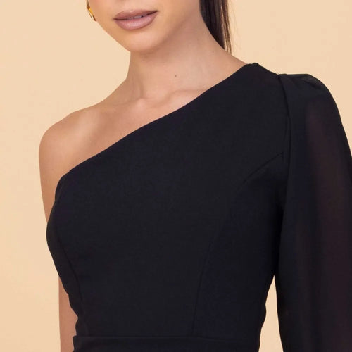Black one-shoulder dress on a beige background