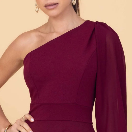 Close-up of a burgundy one-shoulder dress on a beige background