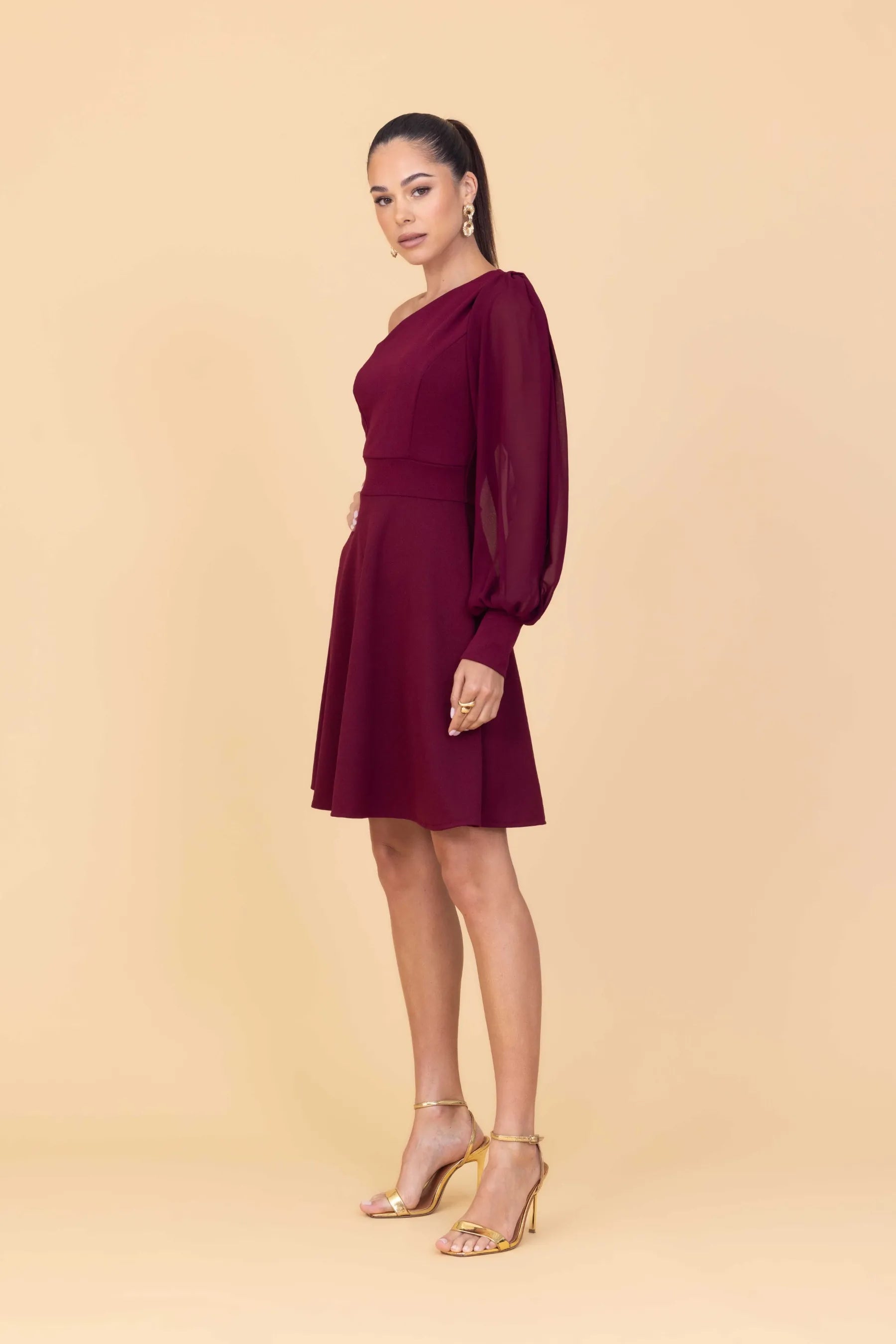 Woman wearing a burgundy dress against a beige background