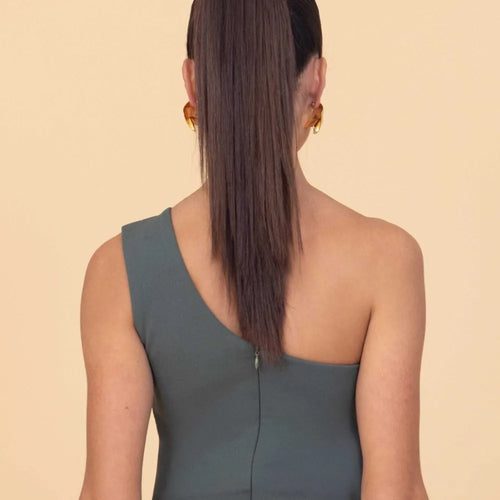 Woman wearing a green dress with a beige background