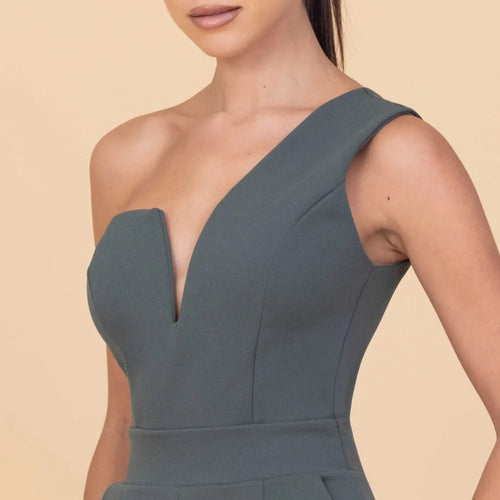 Woman wearing a sleeveless green dress on a beige background